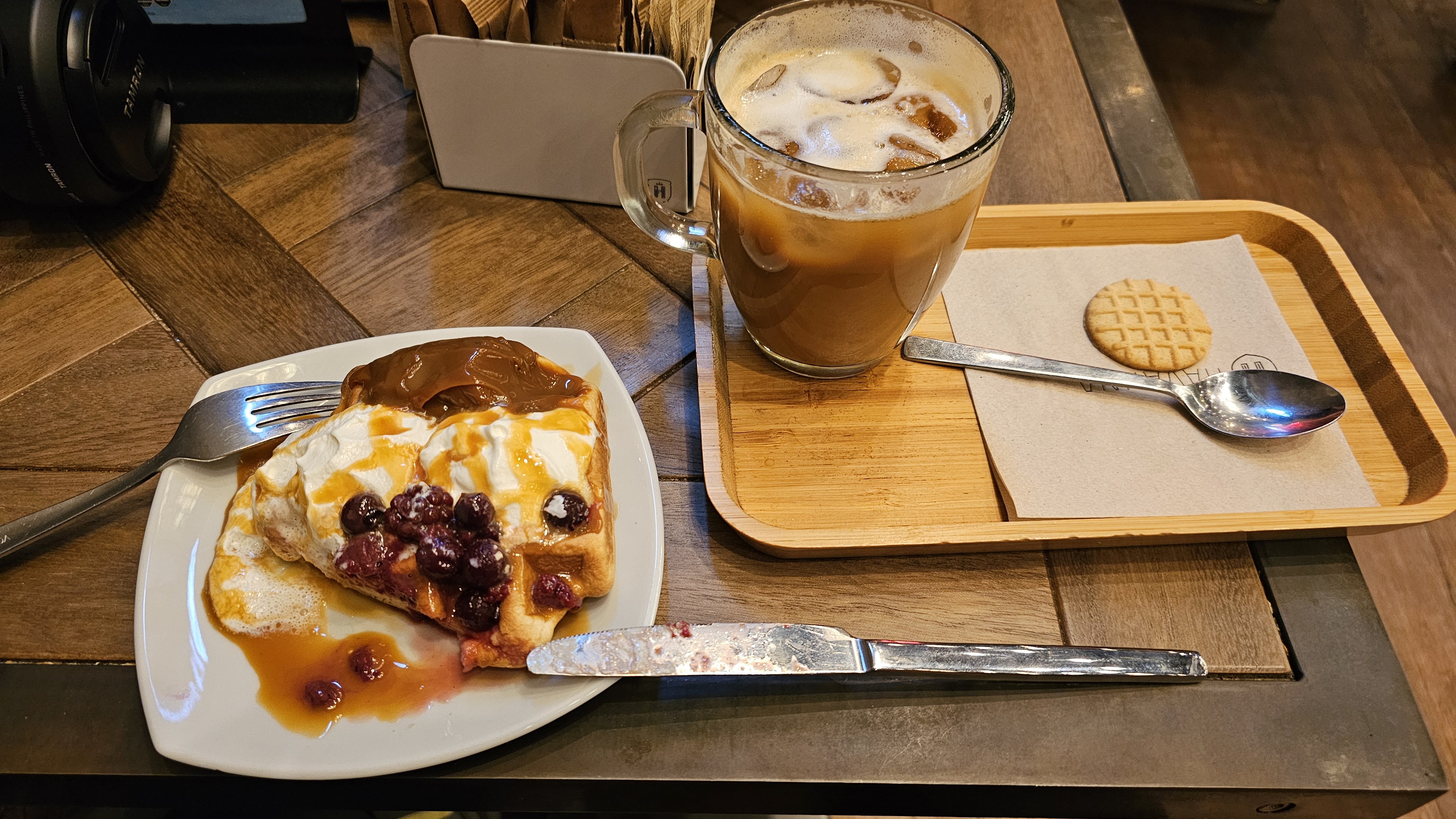 Coffee and dessert plate on wooden tray.