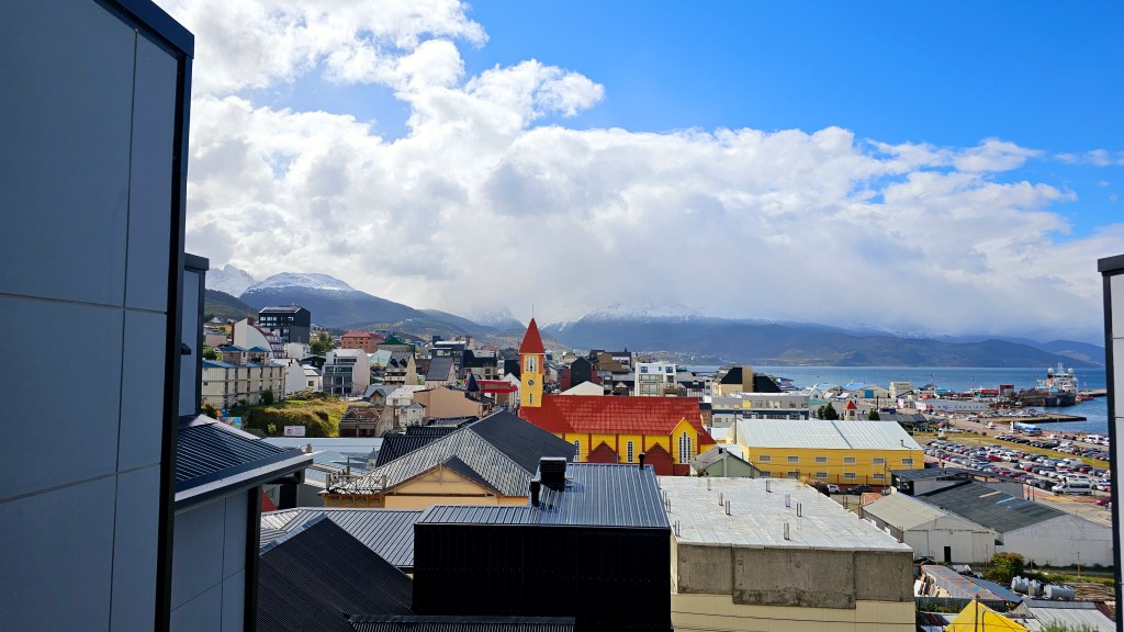 Rooftops and red church in Ushuaia under a dramatic sky