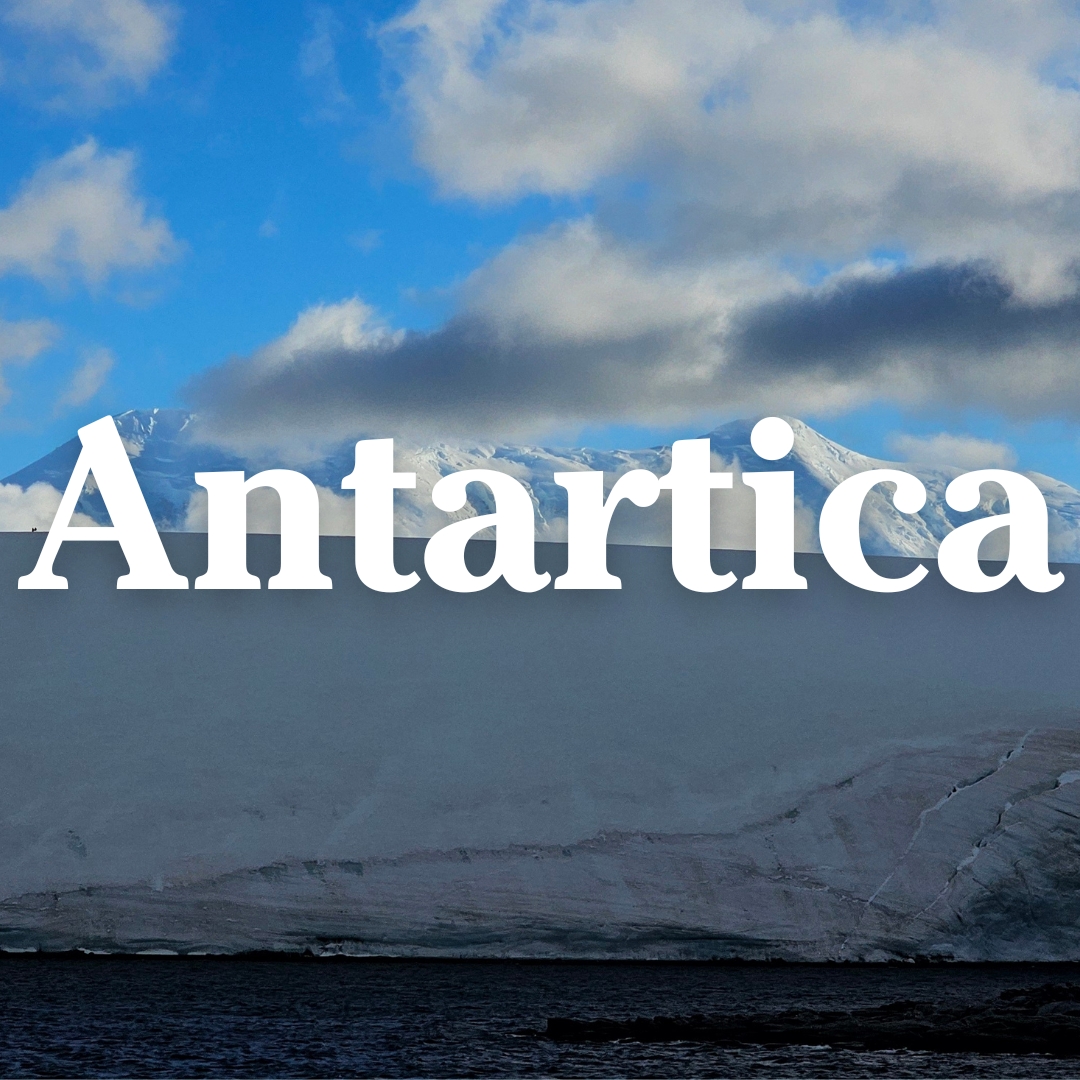 Snow-covered glacier and ocean under dramatic clouds with the word 'Antartica' in bold white letters across the sky.