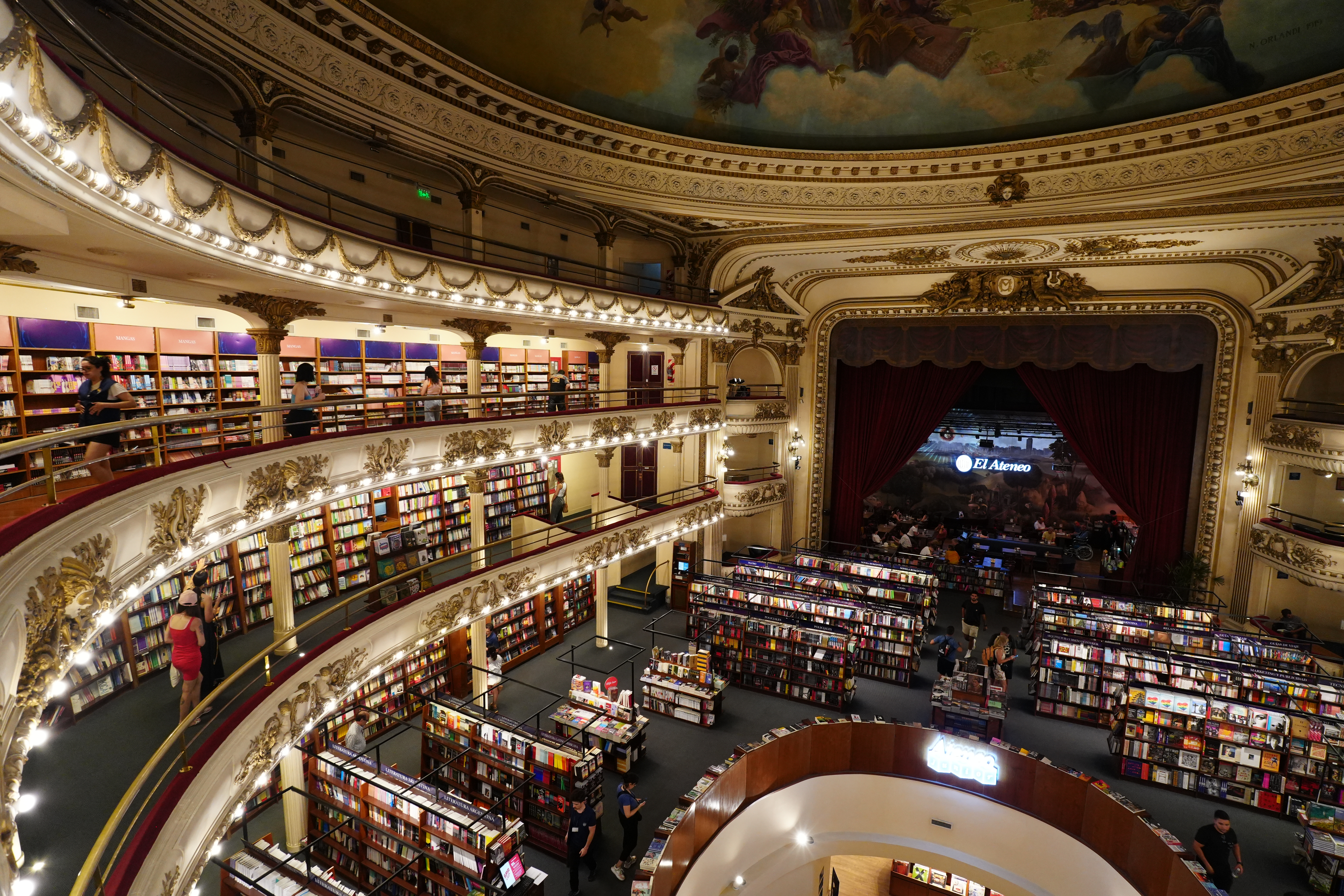 Interior view of El Ateneo showing three balcony levels and stage with red curtain.