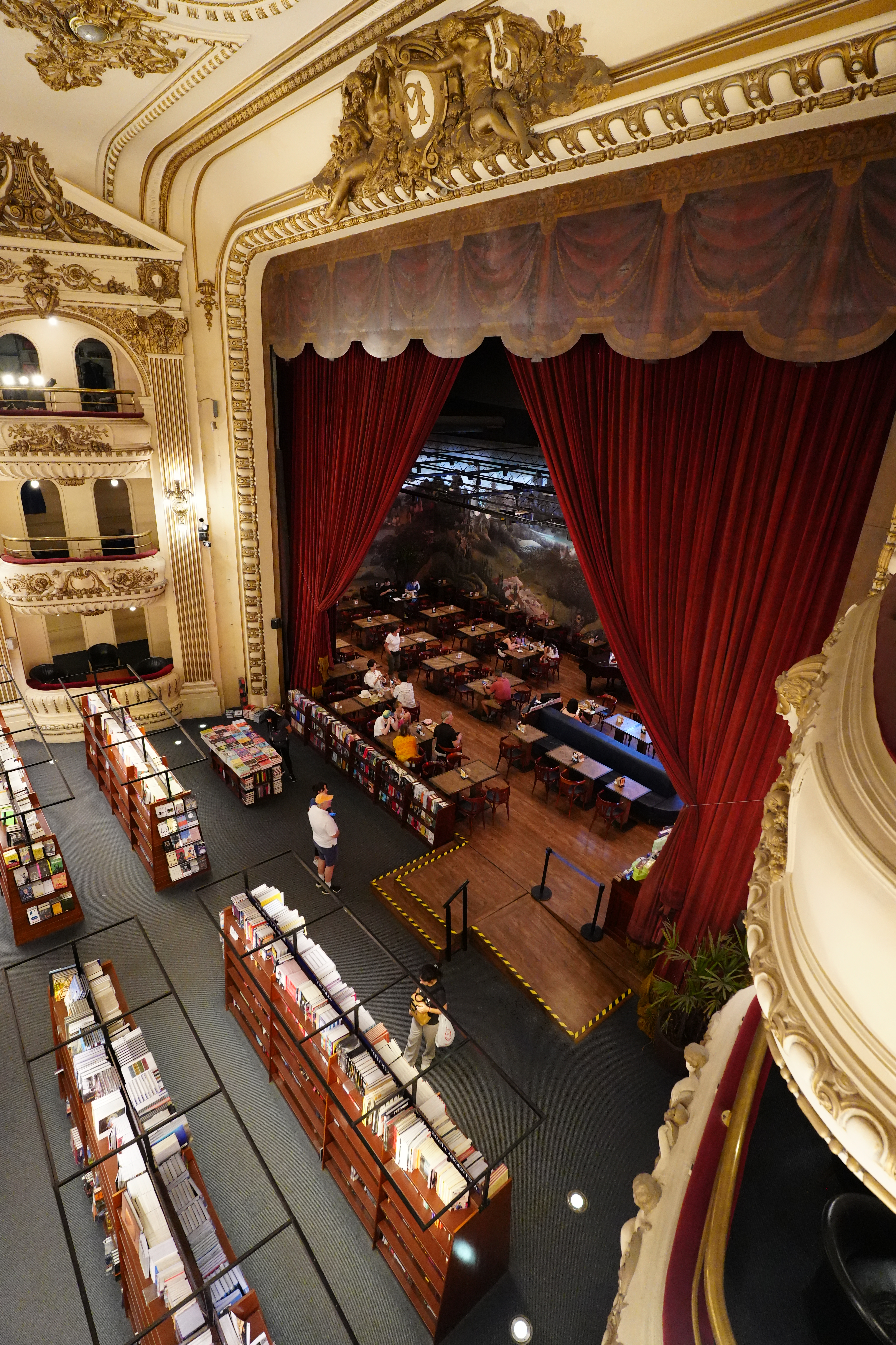 View of El Ateneo stage with red curtains and book displays.