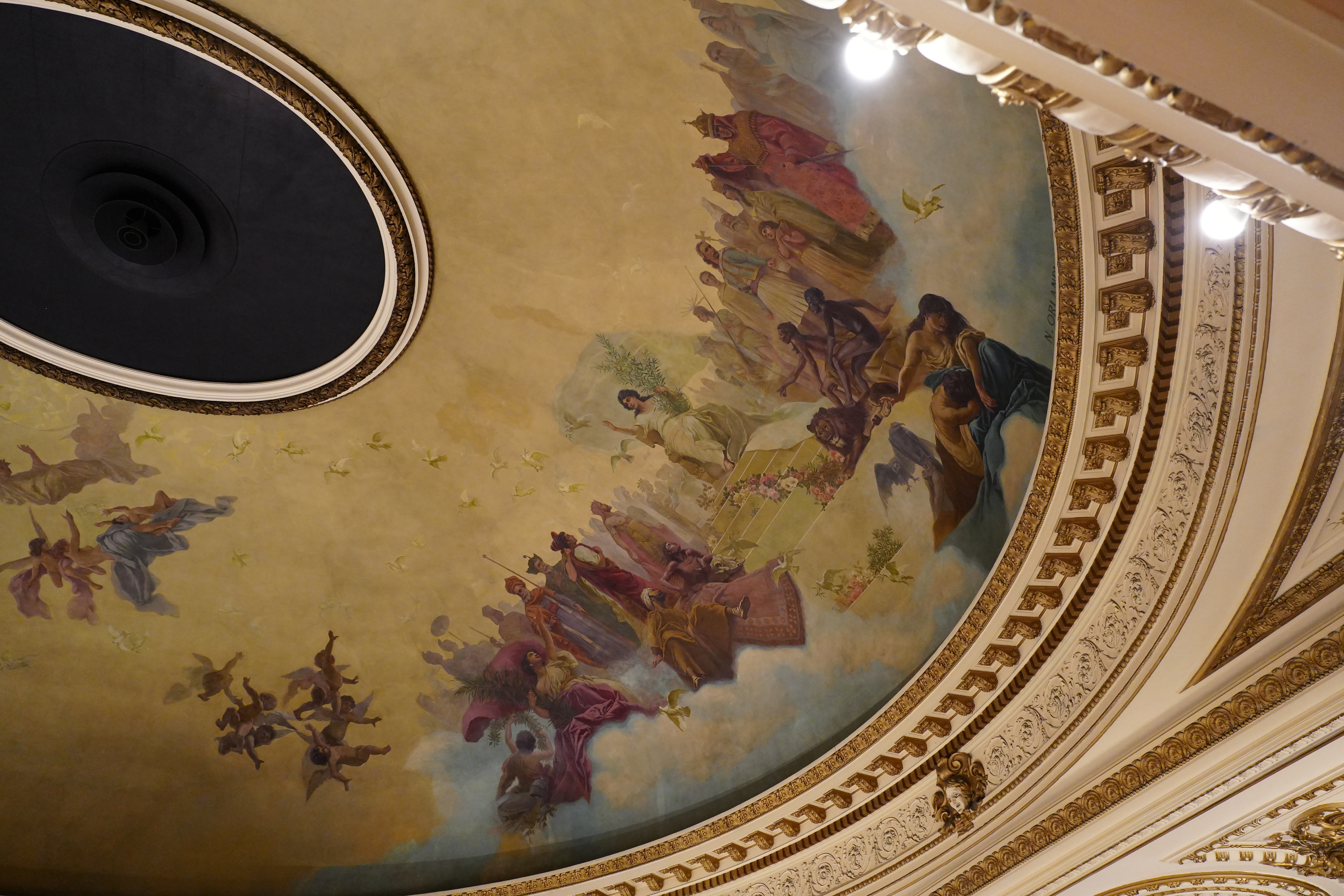 Angled view of curved upper balcony and mural.