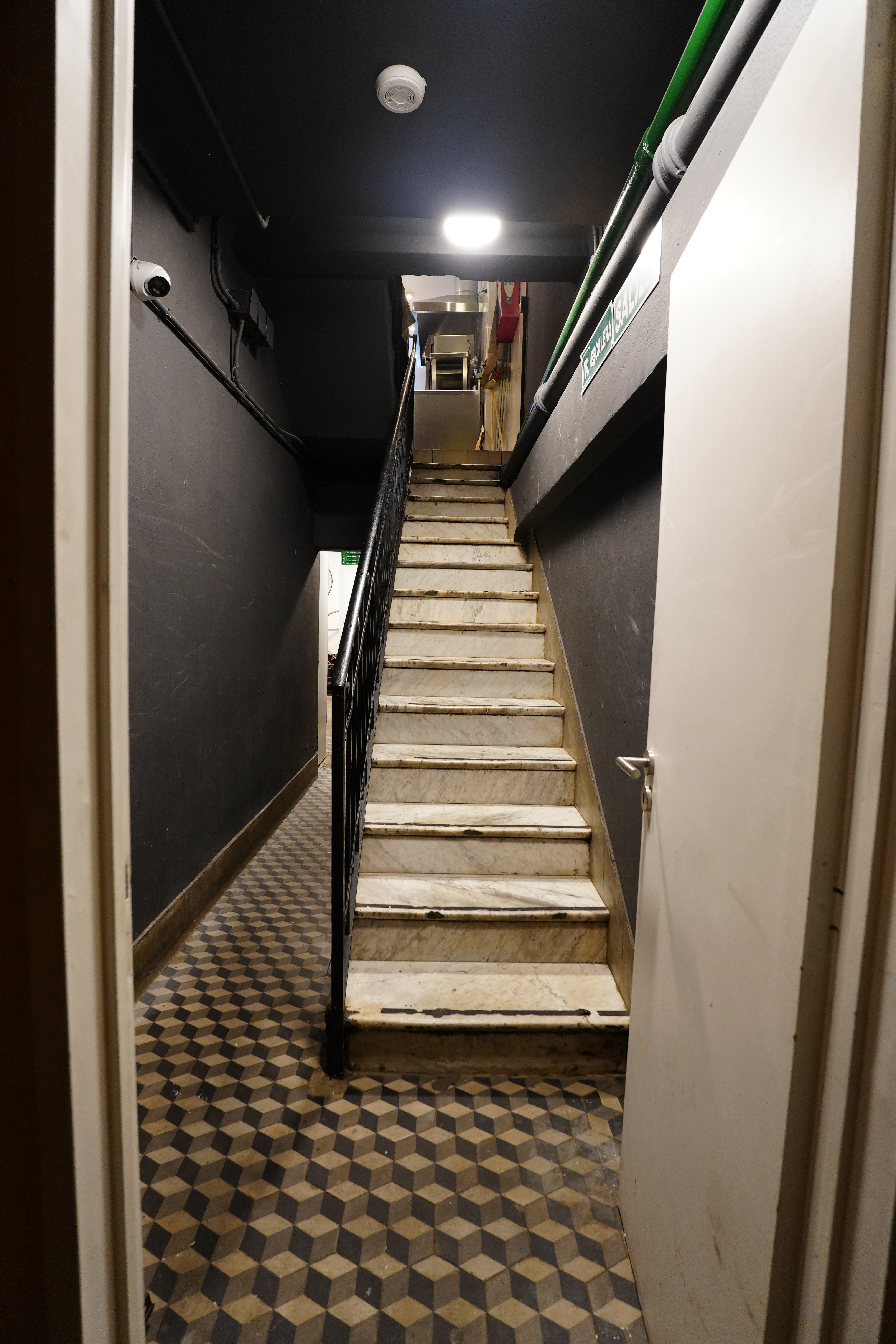 Narrow stone staircase with checkered floor at El Ateneo.	