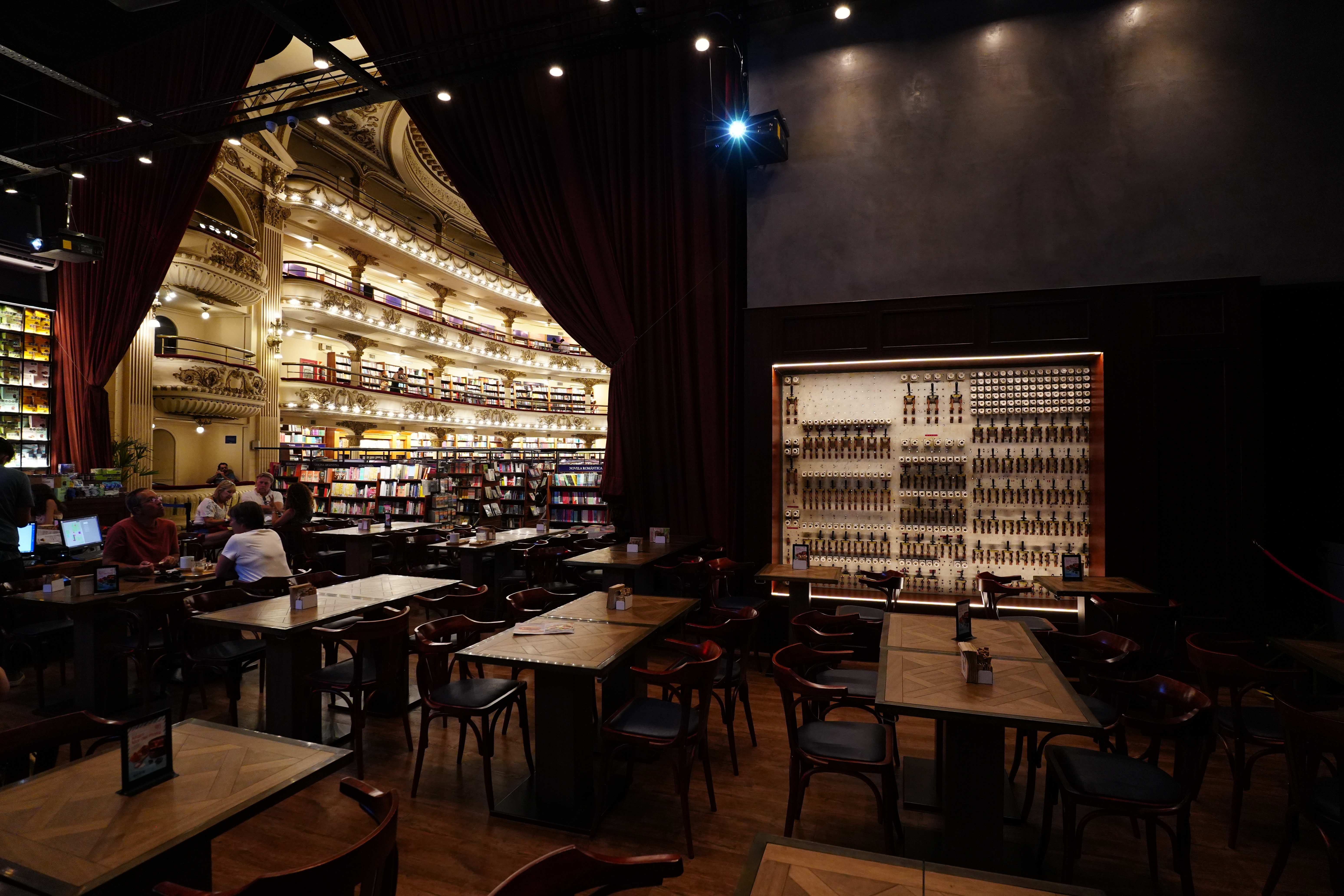 Seating area inside Havanna café with bookshelves and curtain pulls.