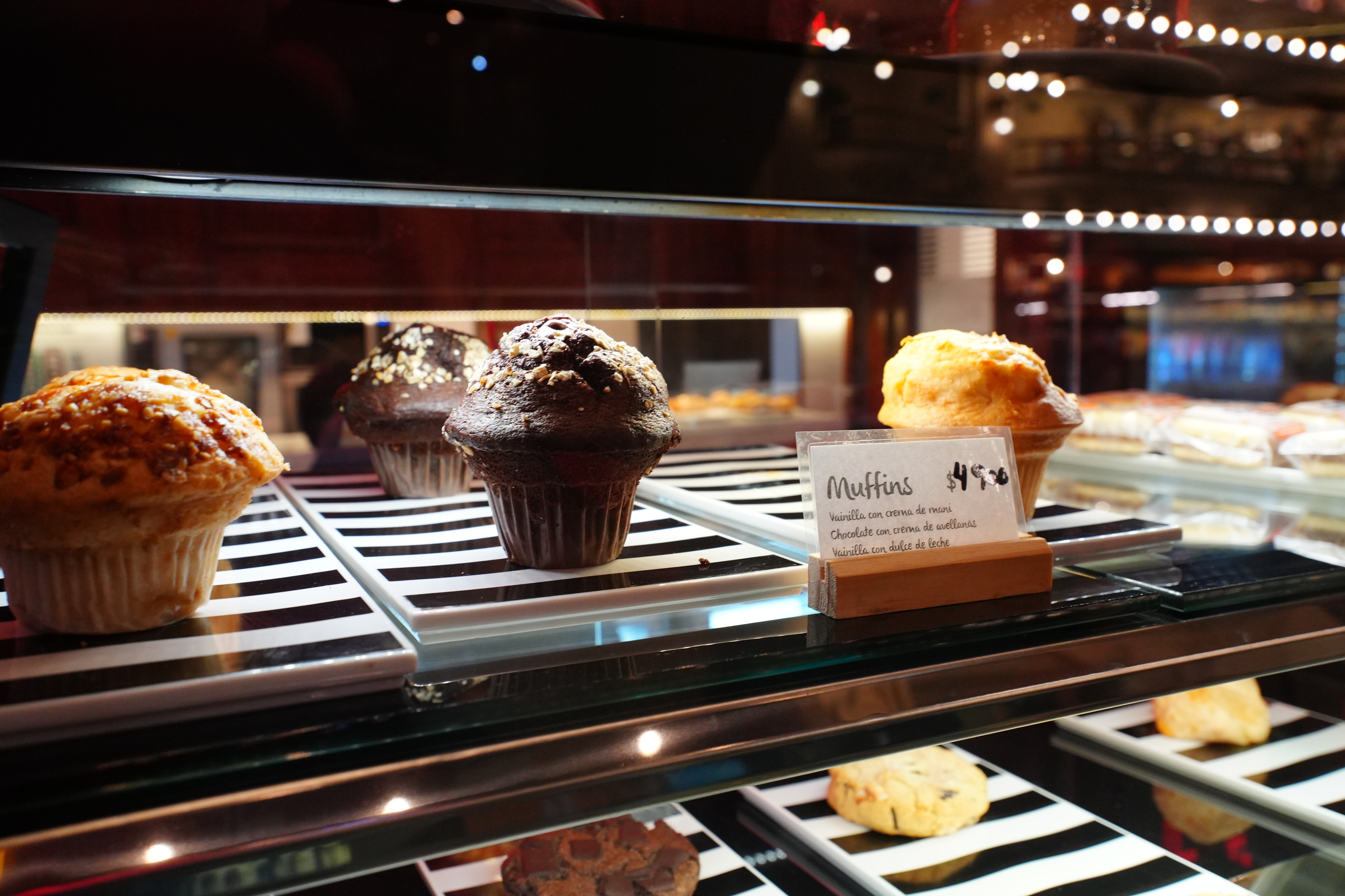 Chocolate muffins in a refrigerated display case.
