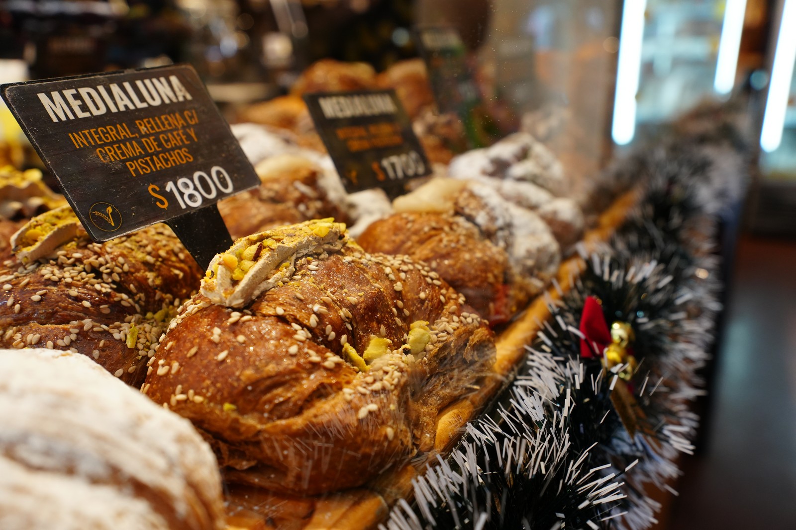 Seeded medialunas in a vegan bakery case