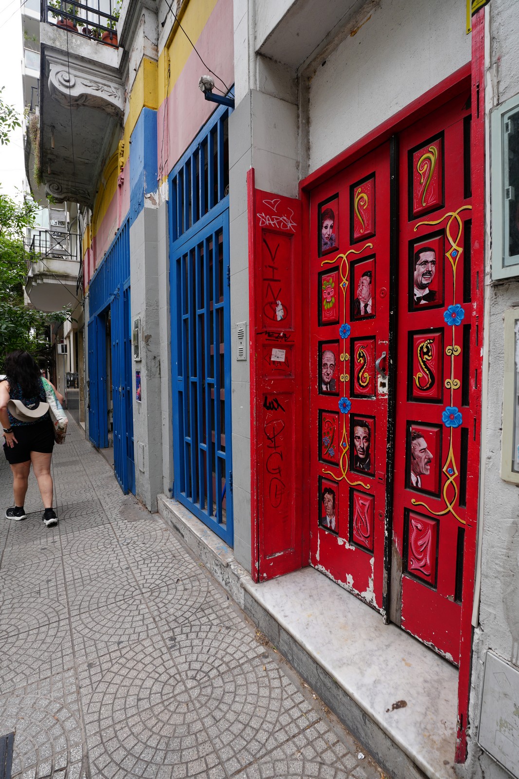 Red and blue gallery-style doorway with small framed art
