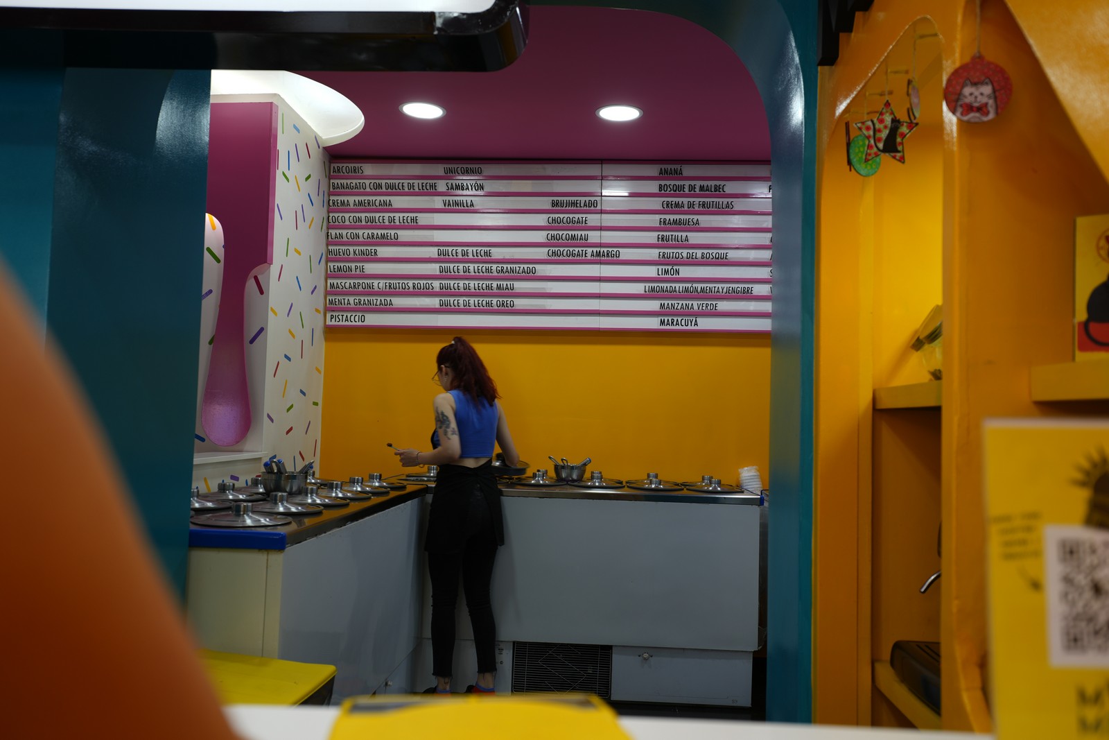 Woman serving up a cold treat at Miau ice cream shop