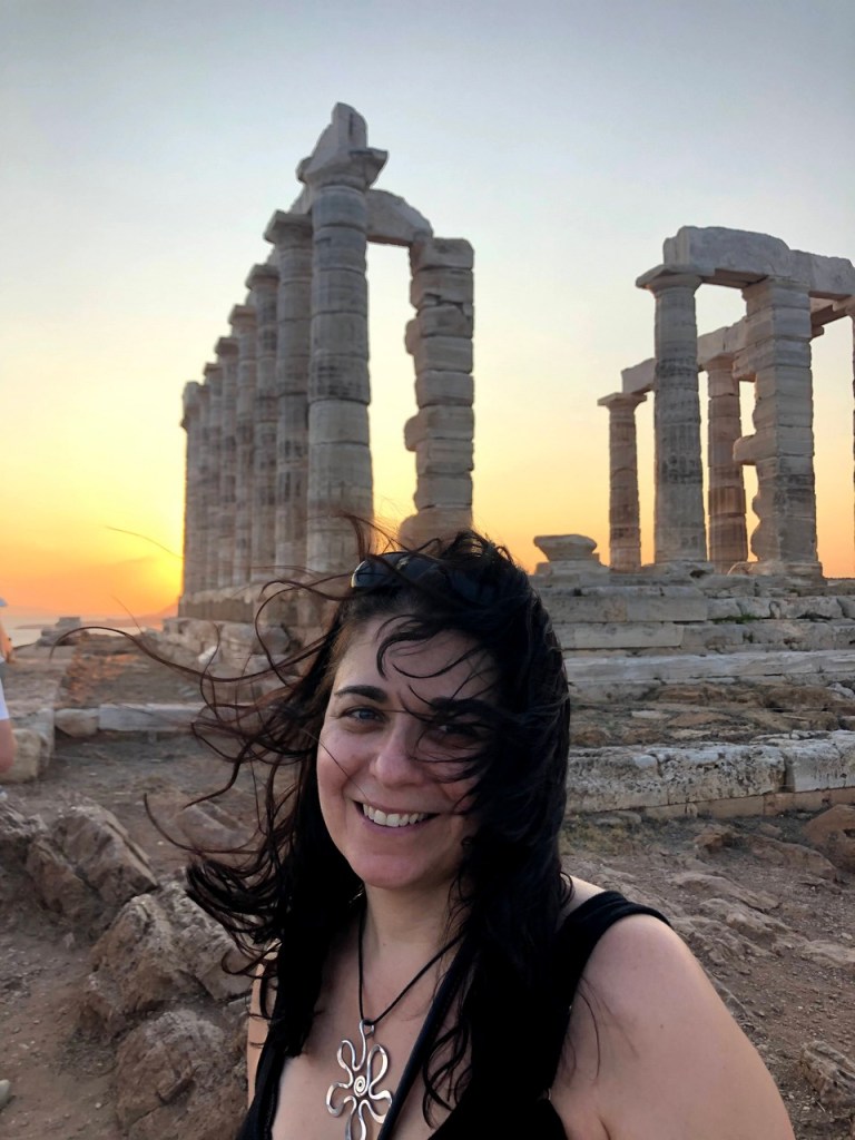 Woman smiling in golden sunset light at the Temple of Poseidon