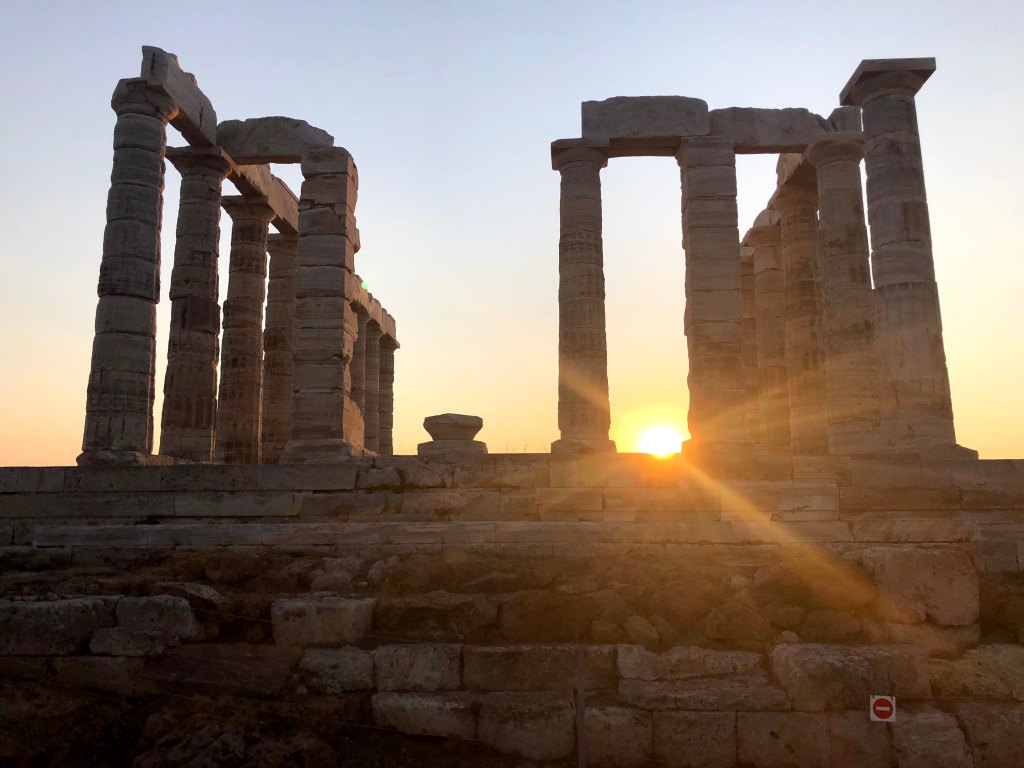 Sunset framed directly between two columns of the Temple of Poseidon