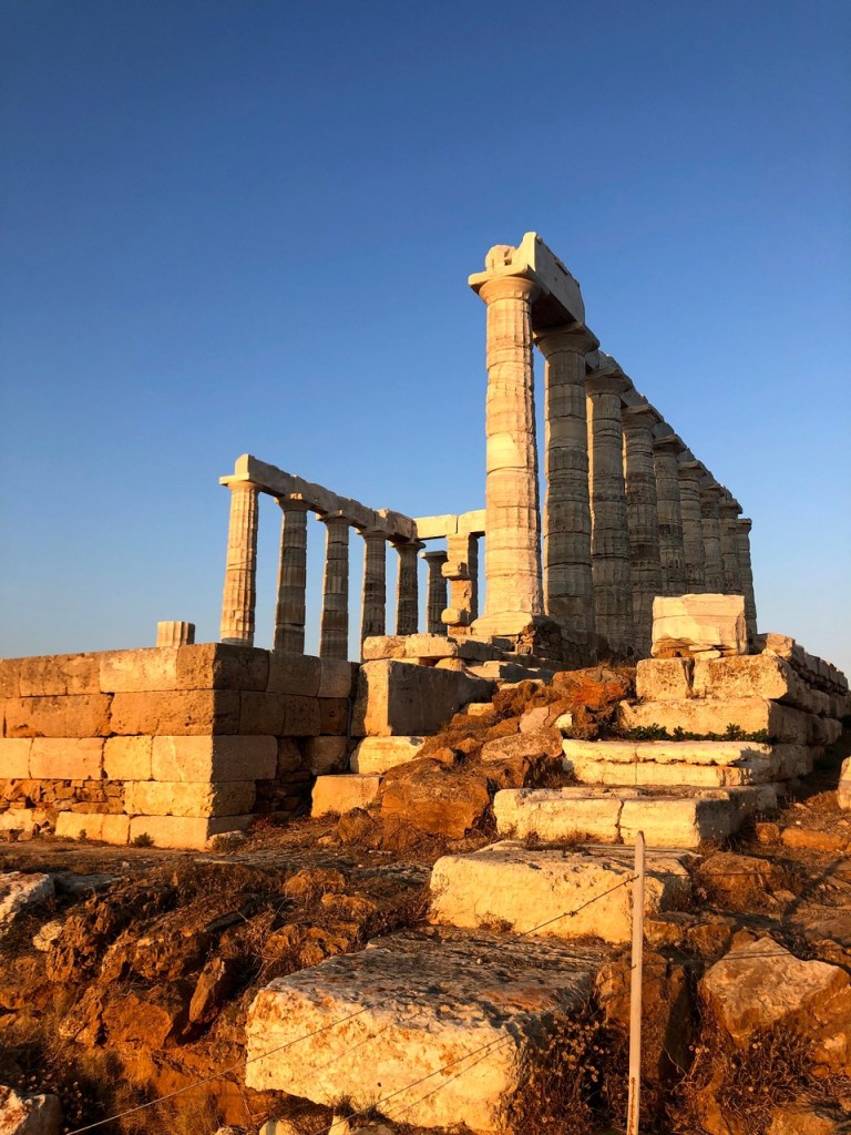 Ancient columns of the Temple of Poseidon at Cape Sounion at summer sunset