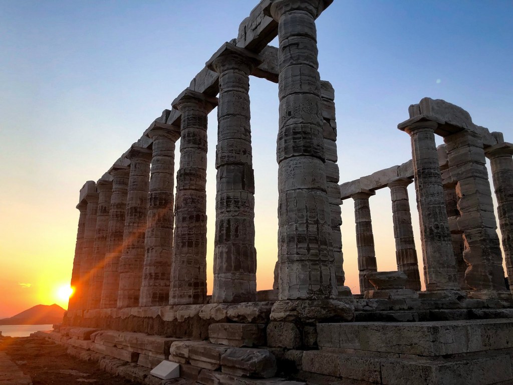 Silhouette of the Temple of Poseidon's columns against the sunset sky