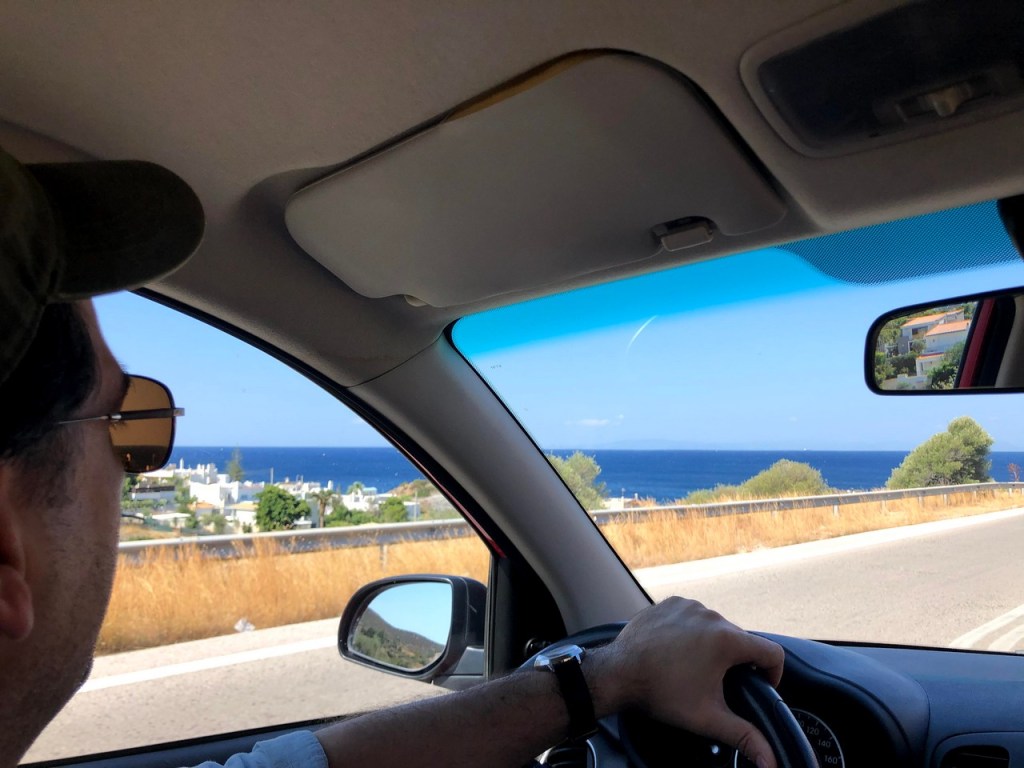 View of the coastal road and sea from inside the car near Cape Sounion